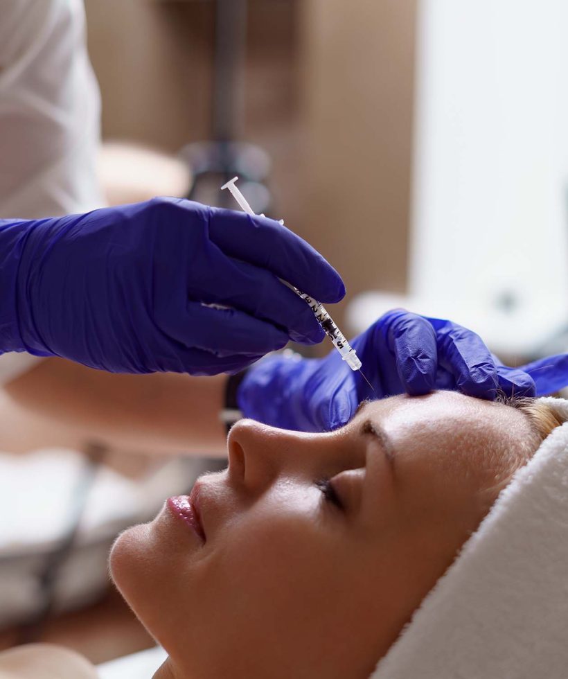 The doctor cosmetologist makes the Rejuvenating facial injections procedure for tightening and smoothing wrinkles on the face skin of a adult woman in a beauty salon